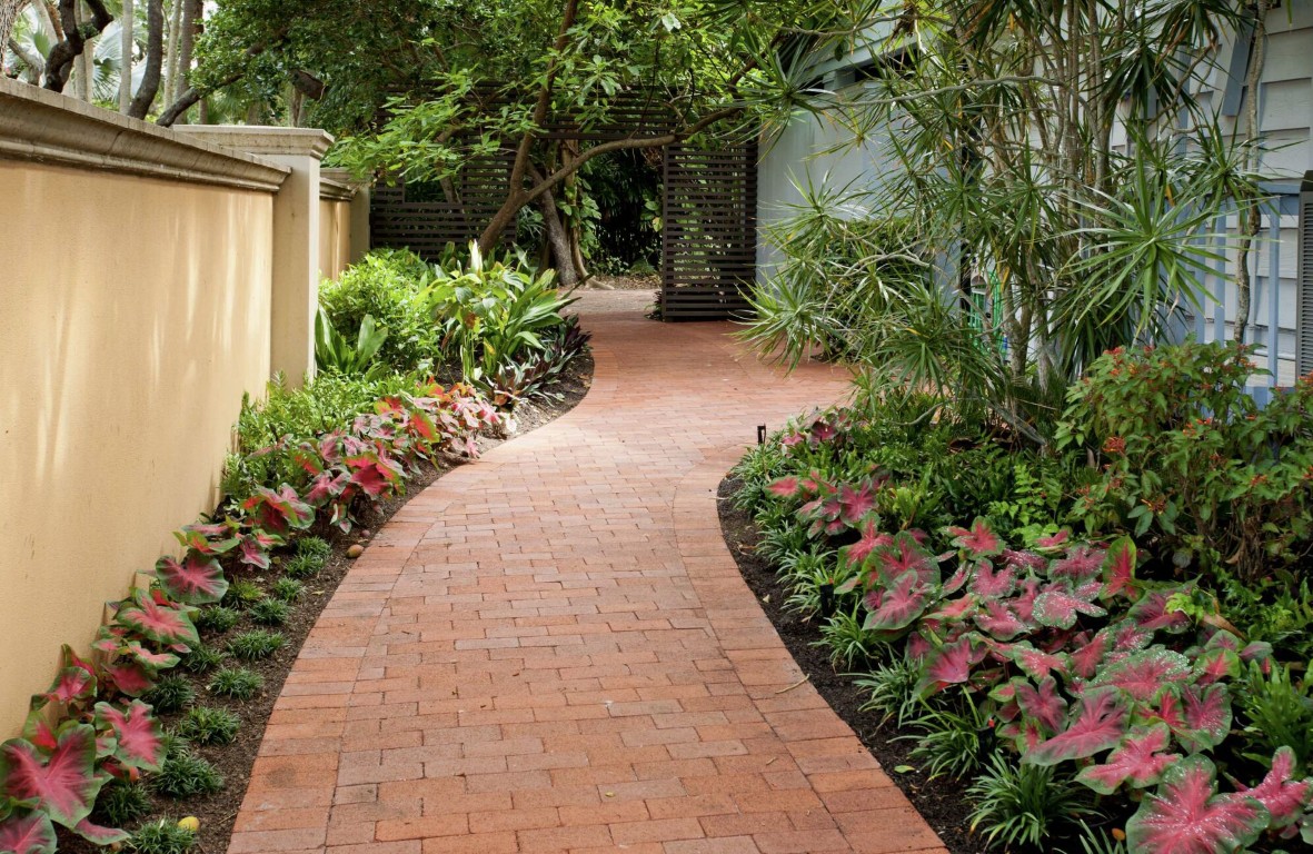 Professional landscape design with curved brick pathway and plant beds